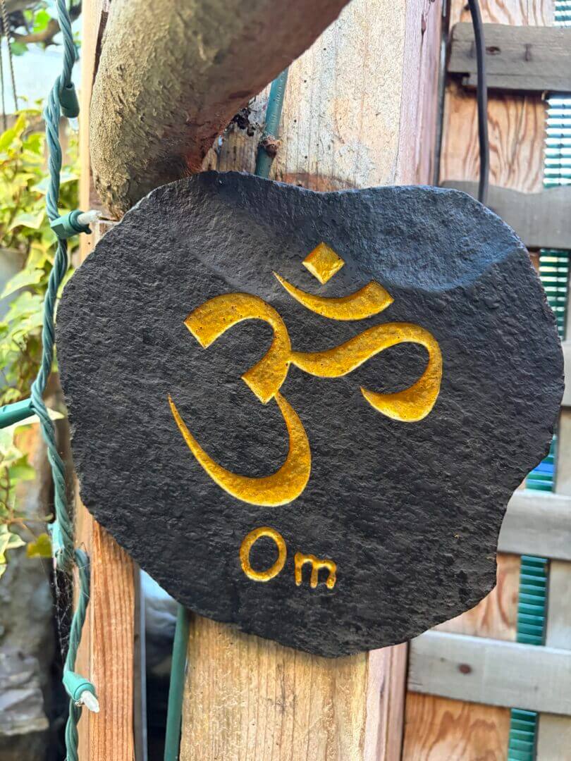 Gold Om symbol carved on black stone plaque