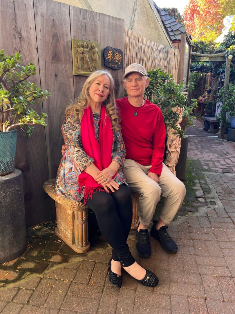 Couple seated on carved bench in courtyard