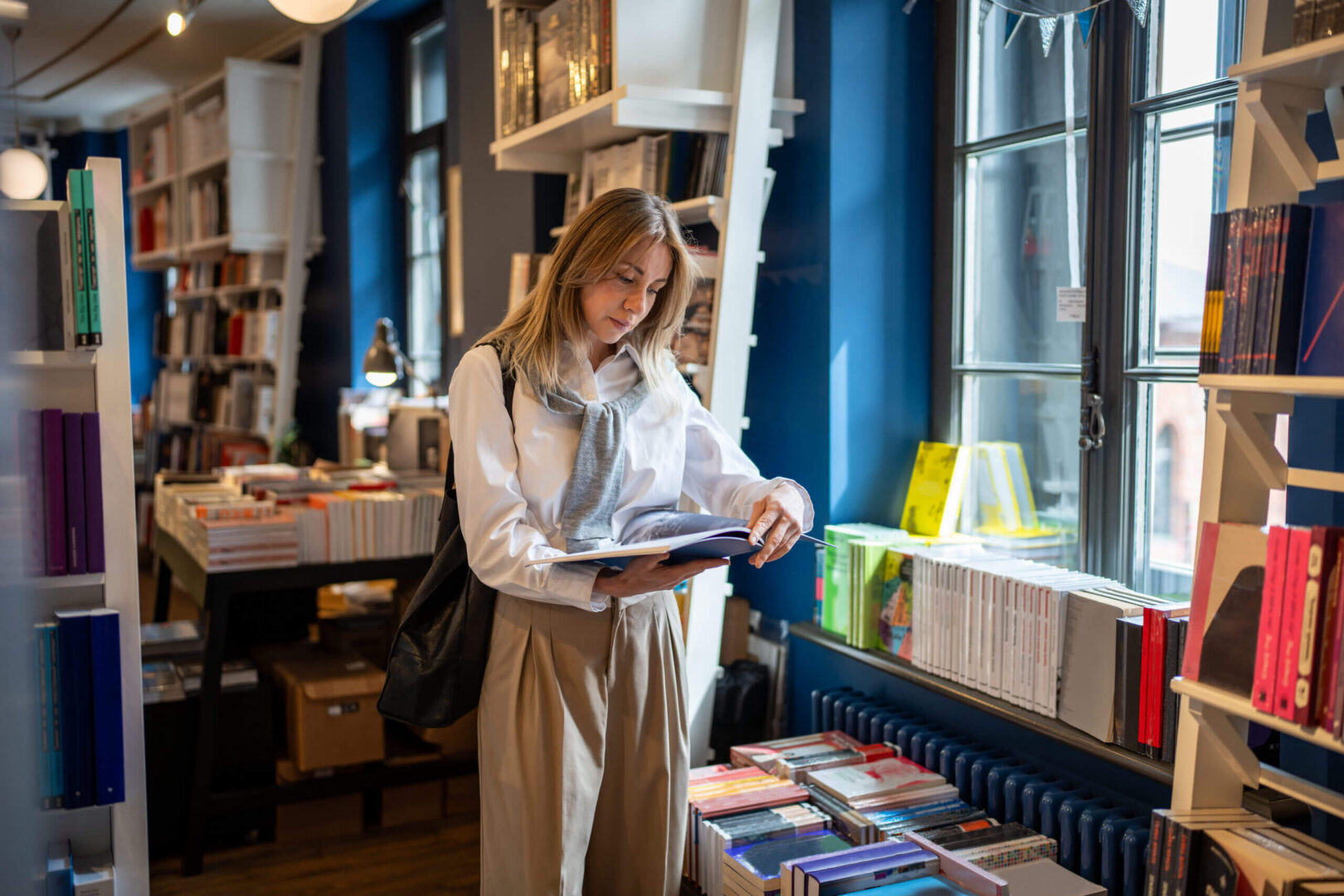 Woman browsing books in cozy bookstore