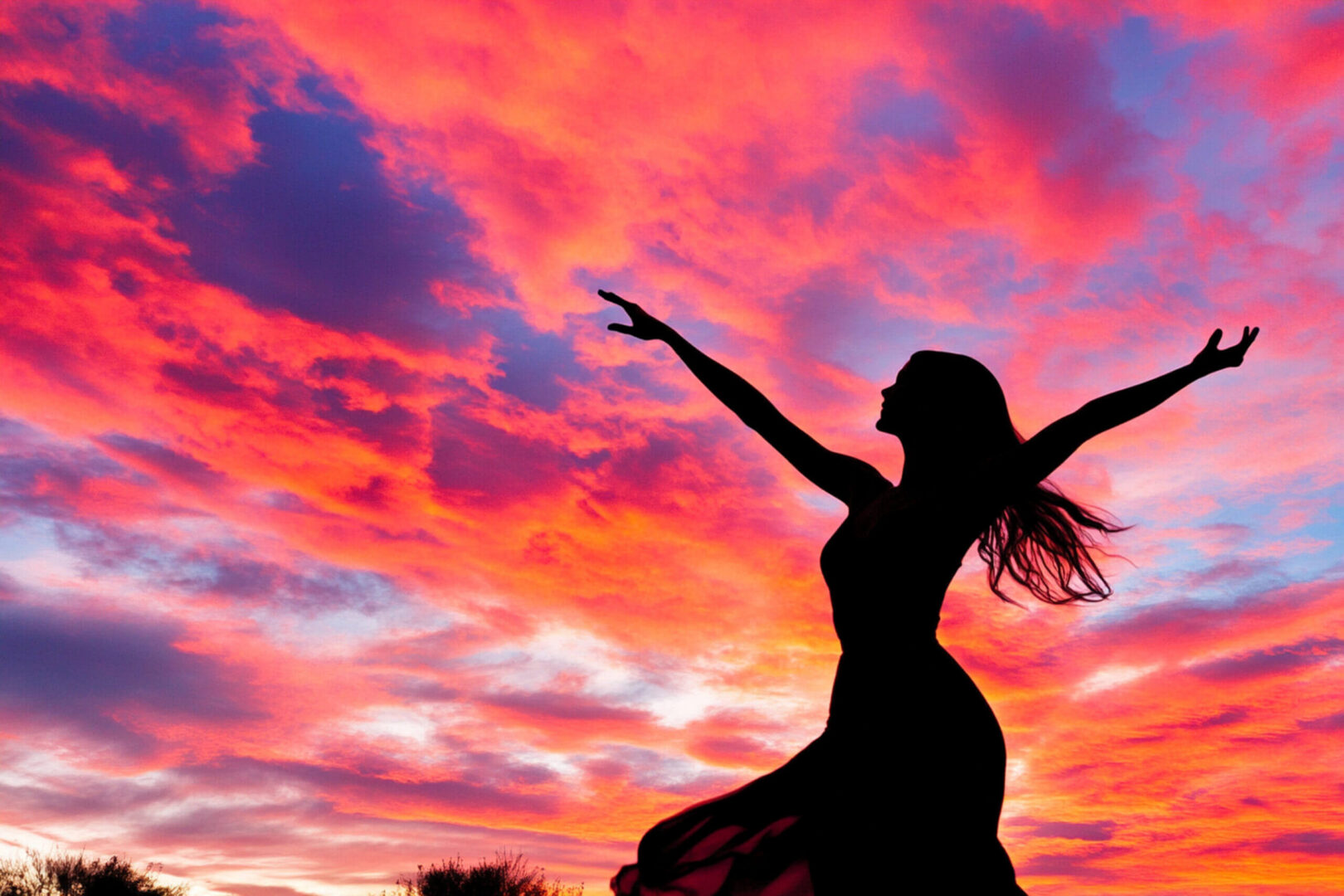 Silhouette dancer against vibrant pink and orange sunset