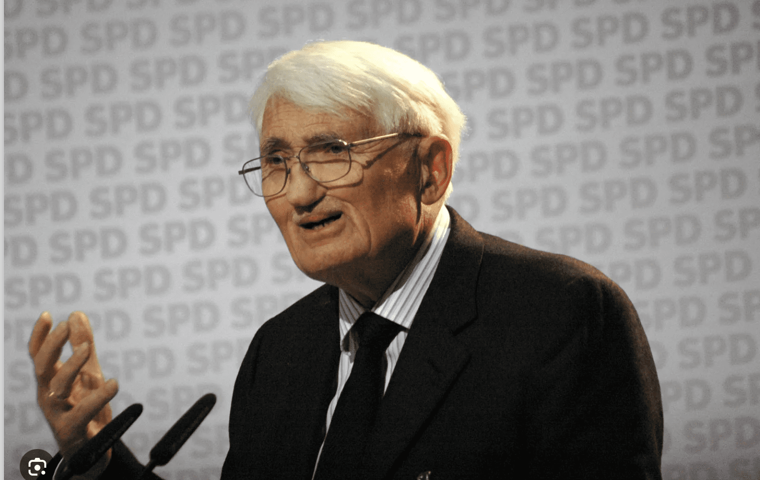 Elderly man speaking at a podium