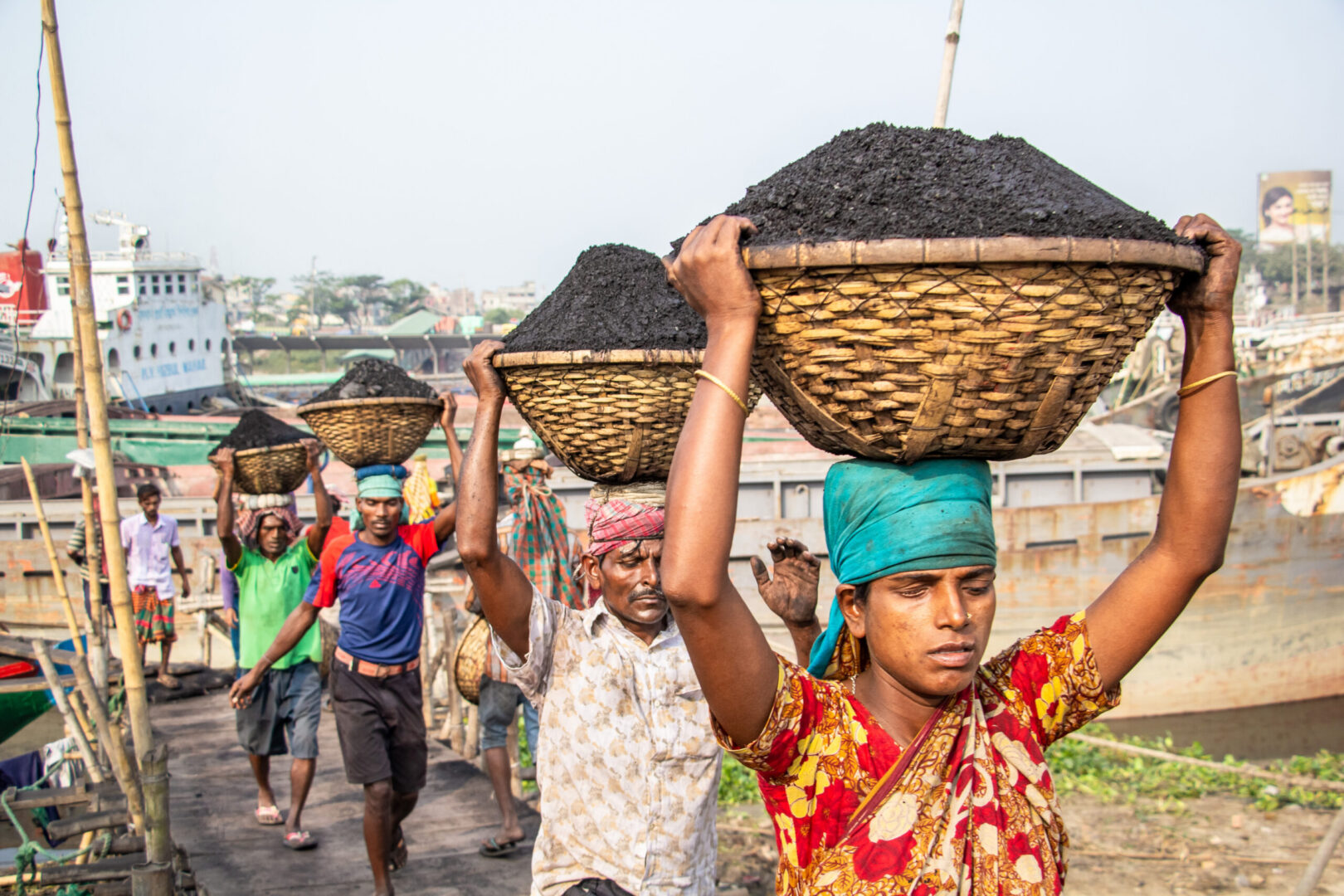 Workers carrying baskets of coal on heads