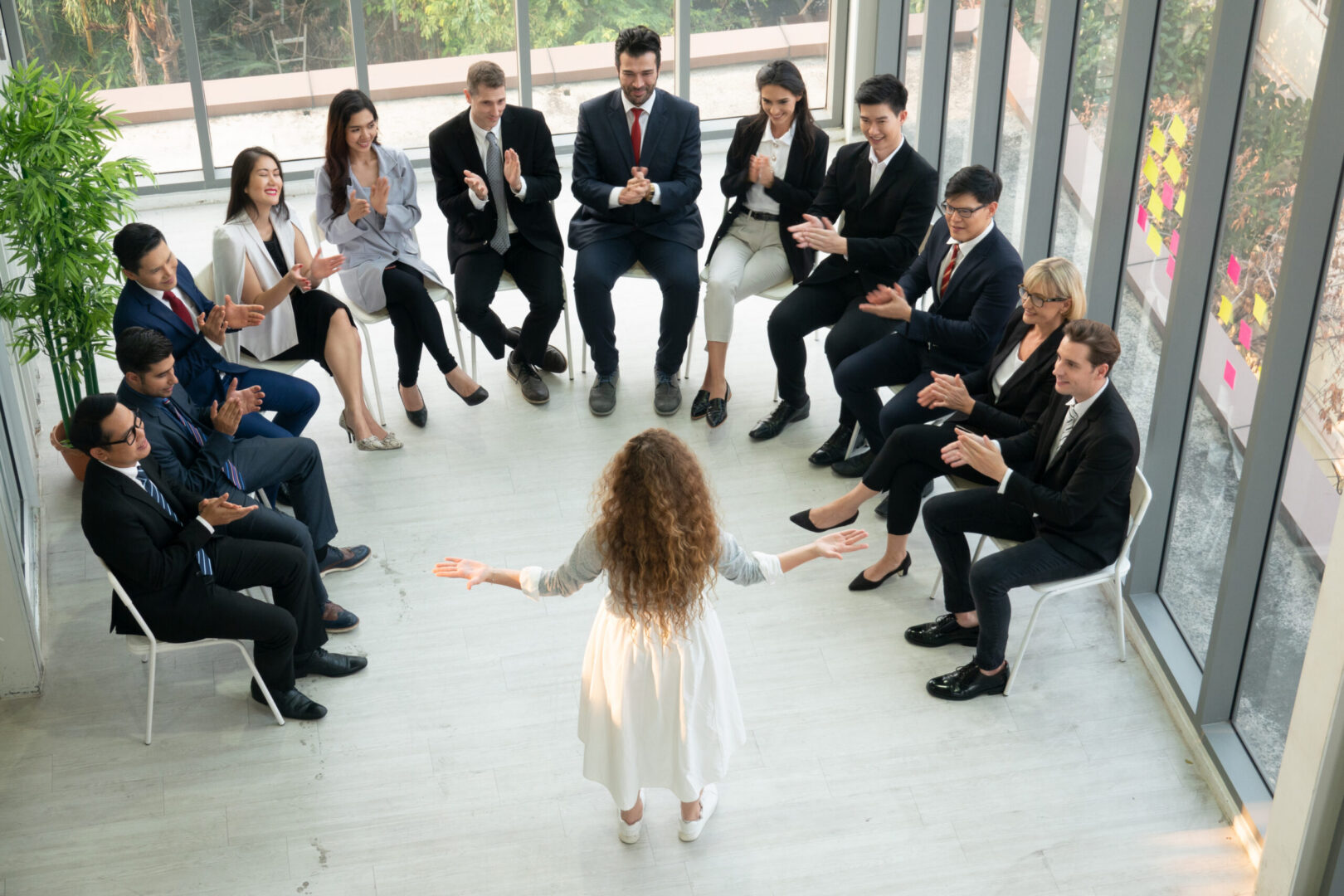 Woman presenting to seated colleagues in circle